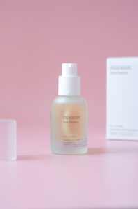 Bottle of Mixsoon - Bean essence 30ml on the pink background